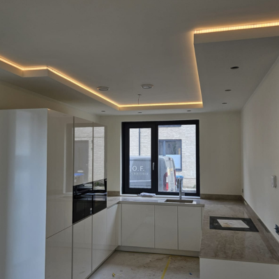 Moderne keuken met strakke wanden en sfeervolle LED-verlichting in het plafond.